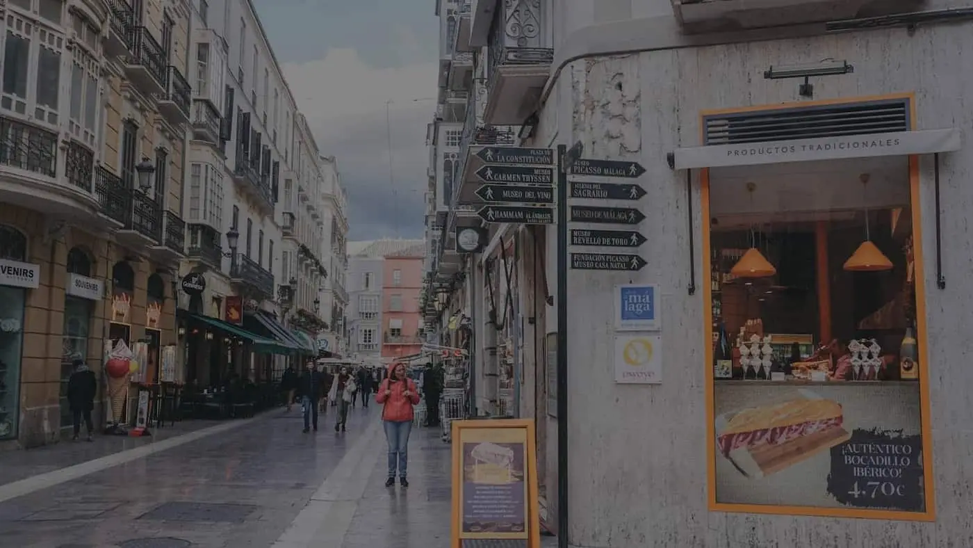 Calle comercial de una ciudad andaluza con escaparates y terrazas